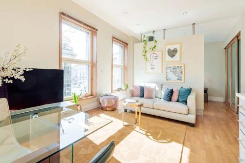 a living room with a couch and a tv at Welcome London Piccadilly Circus in London