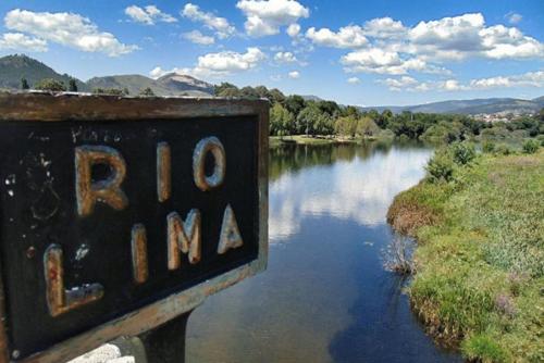 a sign that reads bmo maan next to a river at River House Viana in Viana do Castelo