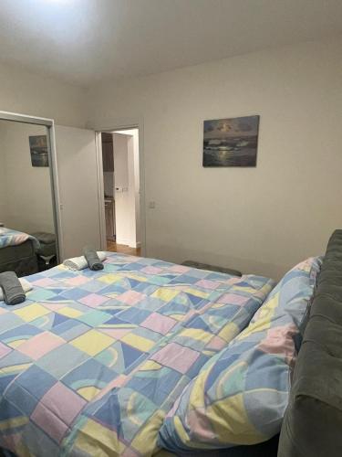 a bedroom with a bed with a colorful comforter at Cvetanov trg LUX 3 in Belgrade