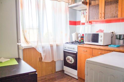 a small kitchen with a stove and a microwave at Панама in Petropavlovsk