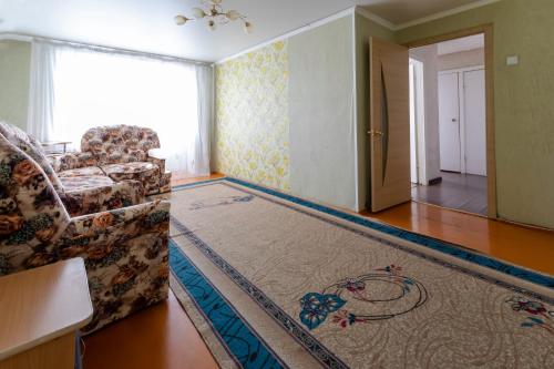 a living room with a couch and a rug at Панама in Petropavlovsk