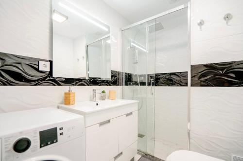 een witte badkamer met douche en wastafel bij Sunset in Armação de Pêra