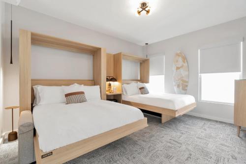 アズベリー・パークにあるThe St Laurent Guest Roomsのベッドが2つと窓があるホテルの部屋