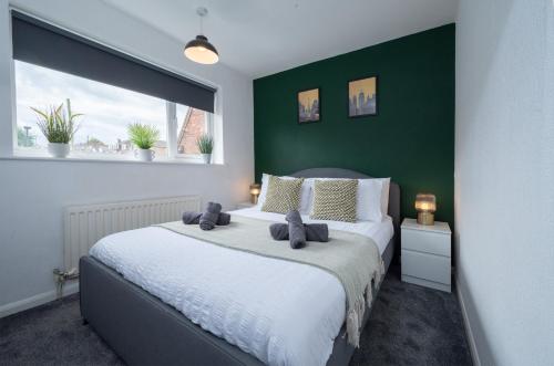 PolesworthにあるSpacious 5-bedroom home perfect for large groupsの緑の壁のベッドルーム1室(大型ベッド1台付)