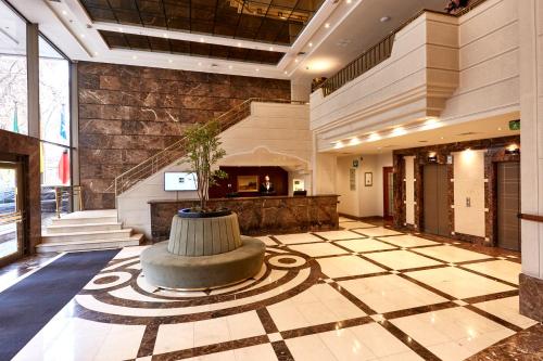 a lobby with a fountain in the center of a building at Plaza El Bosque Ebro in Santiago