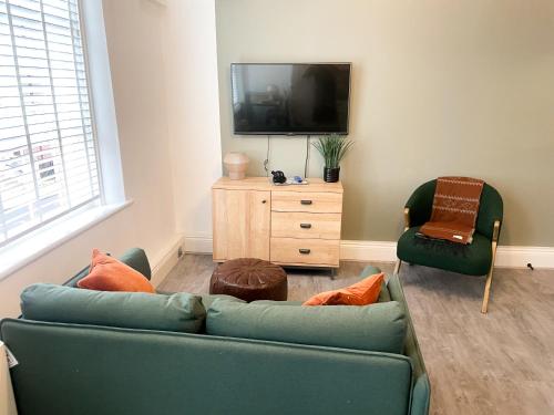 a living room with a green couch and a television at Charming 1BR Apartment in Nottingham in Nottingham