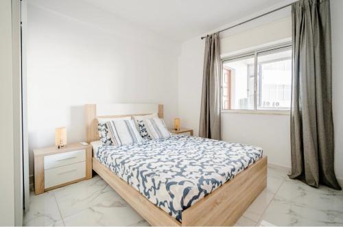 een slaapkamer met een bed en een raam bij Sunset in Armação de Pêra