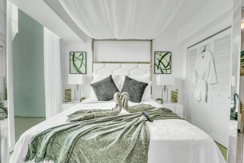 a white bedroom with a large bed with a large headboard at Modern 2 Story Loft 2BR with Breathtaking Views in Miami