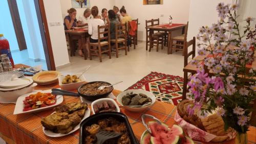 una mesa con comida en ella con gente en una habitación en Kalaja Inn en Krujë