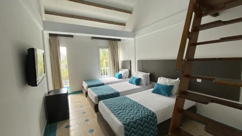 two beds in a room with two bunk beds at On Vacation Blue Cove in San Andrés