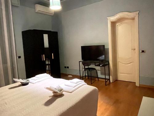 sypialnia z białym łóżkiem i telewizorem w obiekcie Villa Peonia Parma w mieście Parma