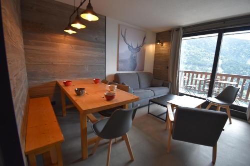 un salon avec une table, des chaises et un canapé dans l'établissement VAUJANYLOCATIONS - COCHETTE II APT 17, à Vaujany