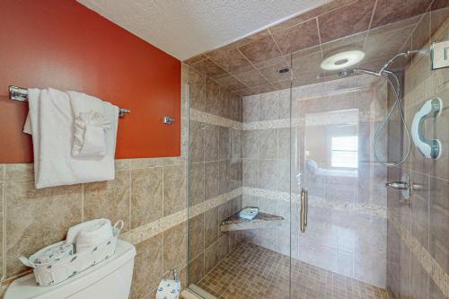a bathroom with a toilet and a glass shower at Sand and Sea Enjoyment Retreat in Ormond Beach