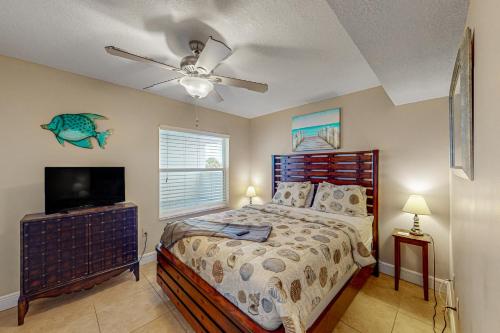 a bedroom with a bed and a flat screen tv at Sand and Sea Enjoyment Retreat in Ormond Beach