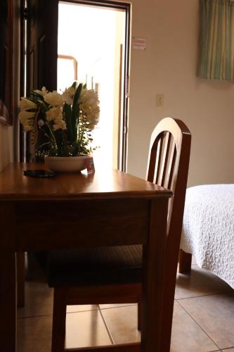 uma mesa de jantar com uma tigela de flores em Hotel Residencial Panamericano em David