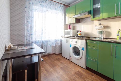 eine Küche mit grünen Schränken und einer Waschmaschine in der Unterkunft Паттайя in Petropawlowsk