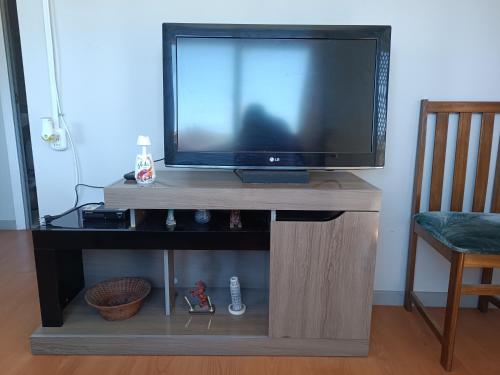 a flat screen tv on a wooden entertainment center at Hospedaje depto 2 habitaciones in Coronel