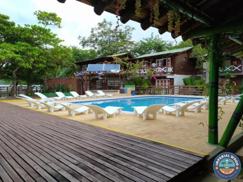 basen z leżakami obok budynku w obiekcie HOTEL IMPERIAL WOOD w mieście Capurganá