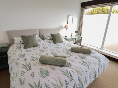 a bedroom with a large bed with green leaves on it at Swallow's Nest in Gainsborough