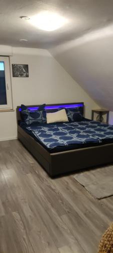 1 dormitorio con 1 cama con edredón azul en Gemütliche 5Pers Ferienwohnung "Am Steinbach" Nürnberger Land Ruhig und gute Anbindung, en Burgthann