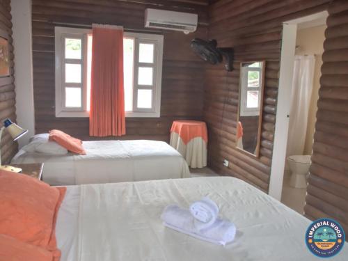 ein Schlafzimmer mit 2 Betten und Handtüchern darauf in der Unterkunft HOTEL IMPERIAL WOOD in Capurganá