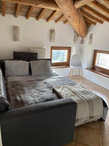 a bedroom with a large bed and a chair at Residence Belvedere ristrutturato vista Wifi in Caprino Veronese