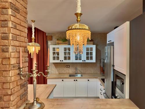 a kitchen with white cabinets and a chandelier at Libelle in Granada
