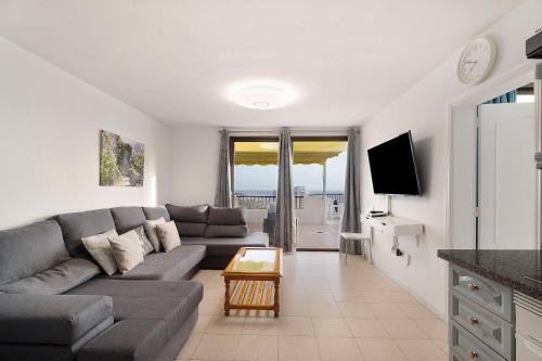 a living room with a couch and a tv at Penthause Luxe 501 sea View pool in Playa Fañabe