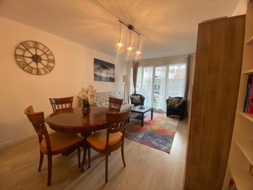 une salle à manger et un salon avec une table et des chaises dans l'établissement Bel appartement de 65 m2, à Saint-Denis