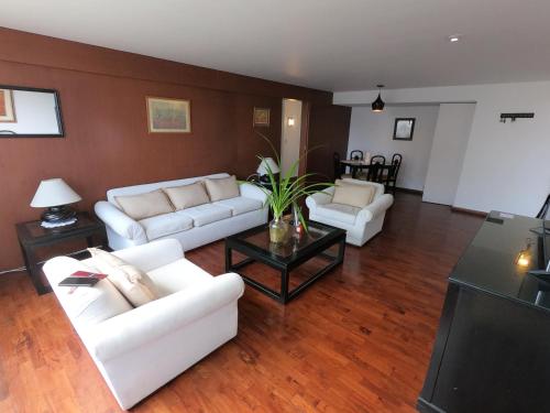 a living room with two white couches and a table at The Guest House 1 at the booming center of Miraflores, Lima - Peru in Lima