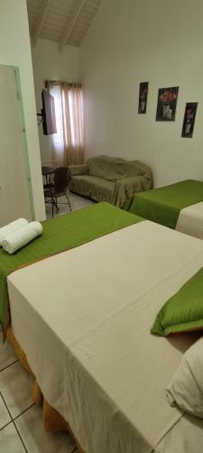 two beds in a room with green and white sheets at E.W.B. Properties in Basseterre