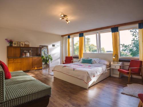 1 dormitorio con 1 cama, 1 silla y ventanas en Terra Farma Cottage, cozy urban escapes here!, 