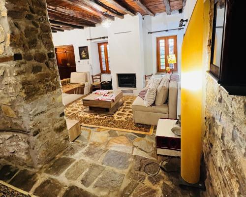 a living room with a stone wall at Villa Tzeni Palios Panteleimon in Panteleímon