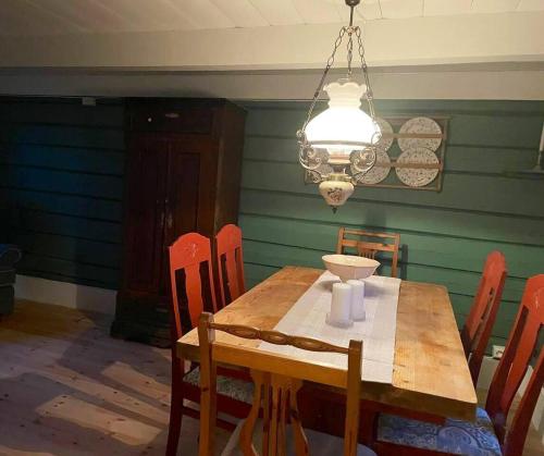 a dining room with a wooden table and a chandelier at Draget gård in Molde