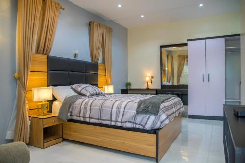 a bedroom with a bed and a desk and a mirror at Lake Luxury Homes in Ibadan