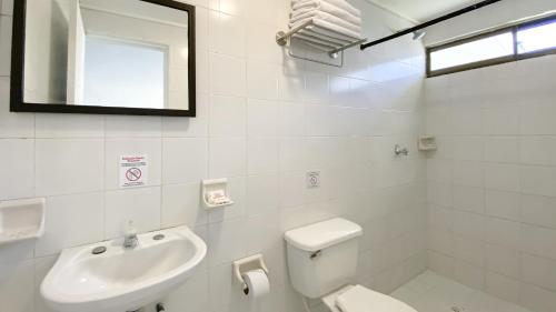 a bathroom with a toilet and a sink and a mirror at On Vacation Blue Reef in San Andrés