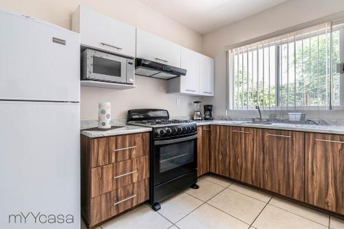 a kitchen with a stove and a refrigerator at Espaciosa Casa Moderna c/ Patio Privado in Aguascalientes