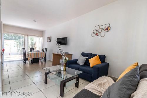 a living room with a blue couch and a table at Espaciosa Casa Moderna c/ Patio Privado in Aguascalientes