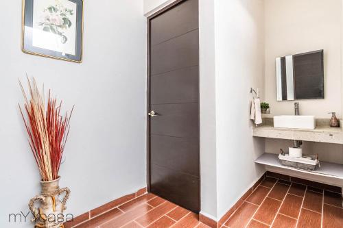 uma casa de banho com uma porta preta e um lavatório em Espaciosa Casa Moderna c/ Patio Privado em Aguascalientes