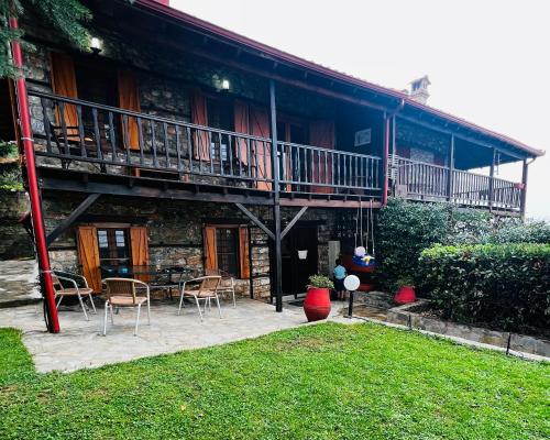 a building with a balcony and a table and chairs at Villa Tzeni Palios Panteleimon in Panteleímon