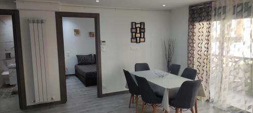 una sala da pranzo con tavolo e sedie bianchi di Appartement F3 moderne en Résidence a Ouled Moussa