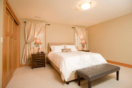 a bedroom with a white bed and two windows at Woodinville's Hollywood Hill Guest House in Woodinville