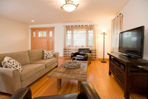 a living room with a couch and a flat screen tv at Woodinville's Hollywood Hill Guest House in Woodinville