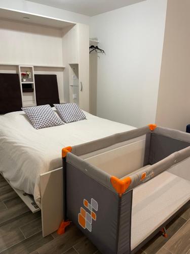 een groot bed in een slaapkamer met een oranje frame bij Appartement RDC avec extérieur in Granville