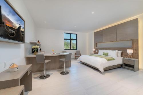 Hotel Cordelia Resort & Spa في لوريتو: غرفة نوم مع سرير كبير ومكتب ومكتب