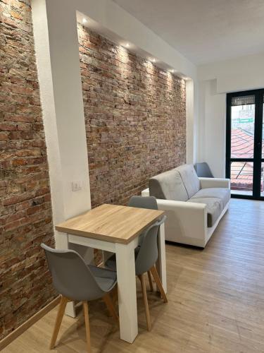 a living room with a table and a brick wall at F&F Appartments in Iglesias