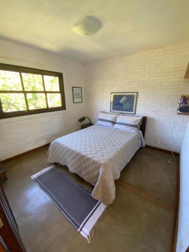 ein Schlafzimmer mit einem Bett und zwei Fenstern in der Unterkunft Sitio-Estalagem Purioca in Cunha