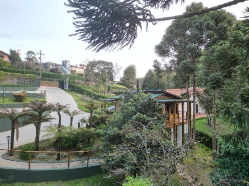 a house in the middle of a park with trees at Pousada Canto da Nascente in Monte Verde