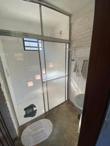 ein Bad mit einer Glasdusche und einem WC in der Unterkunft Sitio-Estalagem Purioca in Cunha