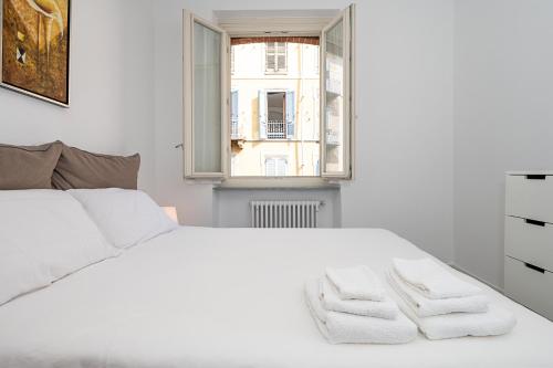 a white bedroom with a white bed and a window at Il Mattone Rosso/zona Politecnico e BorgoSan Paolo in Turin